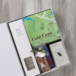 Chocolate, coconut and lime reed diffuser, gourmet nougat, English breakfast tea bags, plus a watercolour-illustrated map cotton tea towel of the Gold Coast and matching greeting card in a gift hamper with free delivery