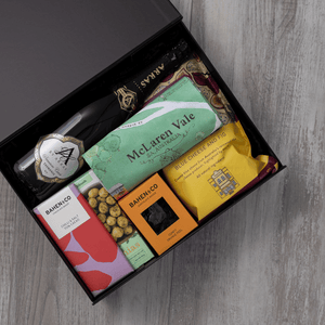 Sparkling wine, gourmet popcorn, artisanal chocolate, hand-roasted macadamias, plus a watercolour-illustrated map cotton tea towel of the McLaren Vale and matching greeting card in a gift hamper with free delivery